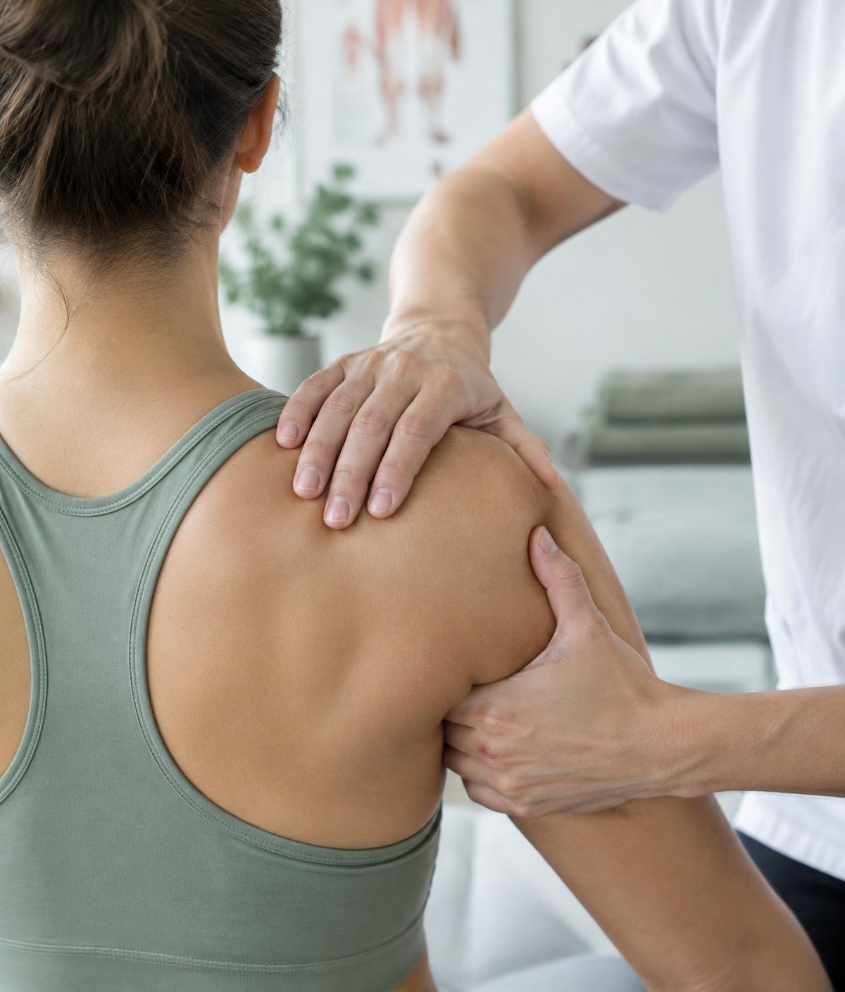 Fisioterapeuta tratando el hombro de una paciente